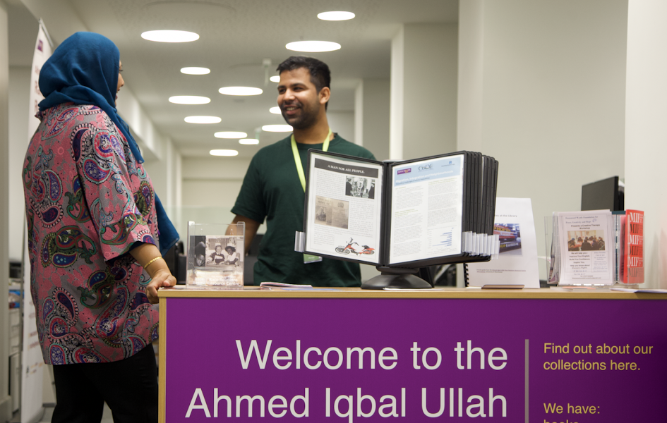 Two people standing at Ahmed Iqbal Ullah RACE Centre desk in Central Library